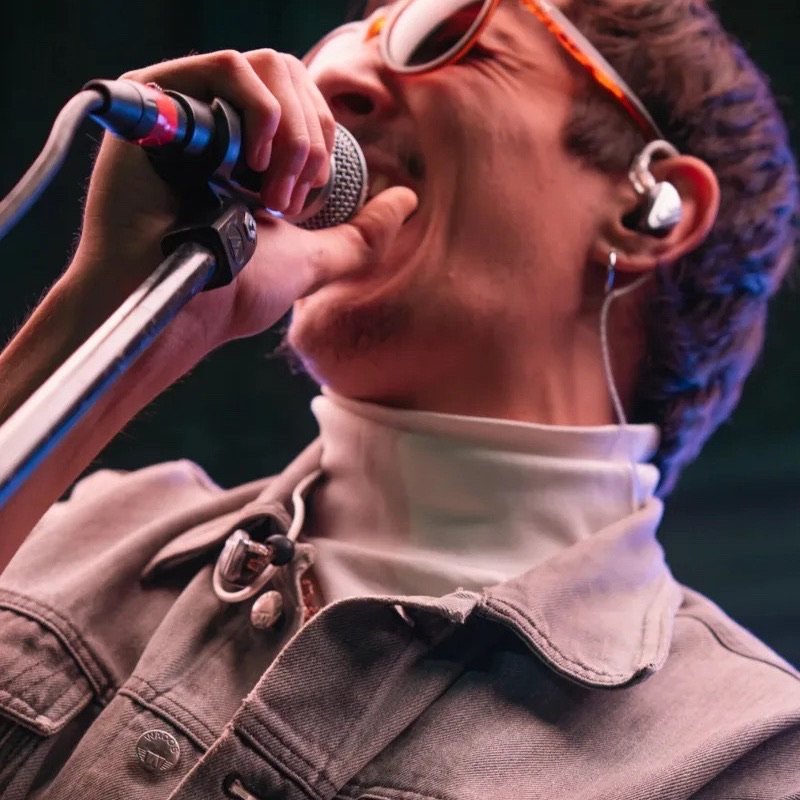 Toto Rovito cantando con el micrófono en un show