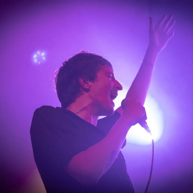 Toto Rovito cantando bajo luces violetas